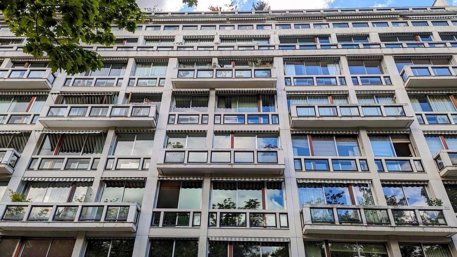 The blue sky is reflected in the windows of the apartment building, the former home of writer Françoise Sagan, next to the Luxembourg Gardens.
