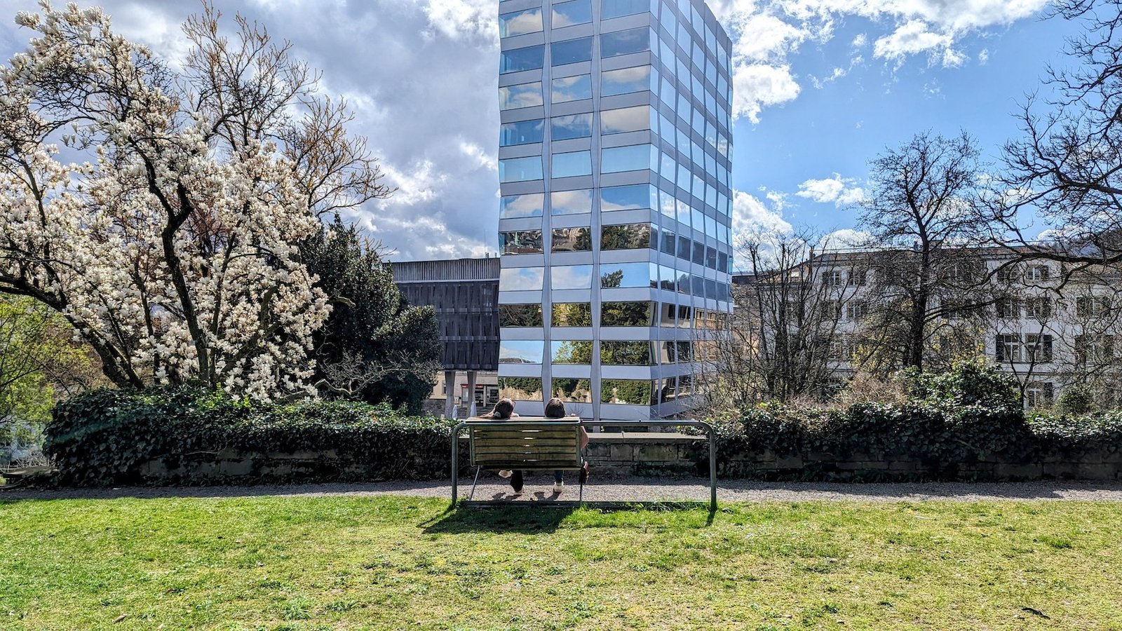Two locals from behind on a park bench in the Alter Botanischer Garten Zurich.