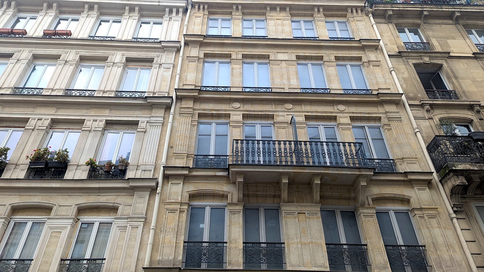 The fake house on 145 Rue La Fayette has visibly darker windows than the neighboring house.