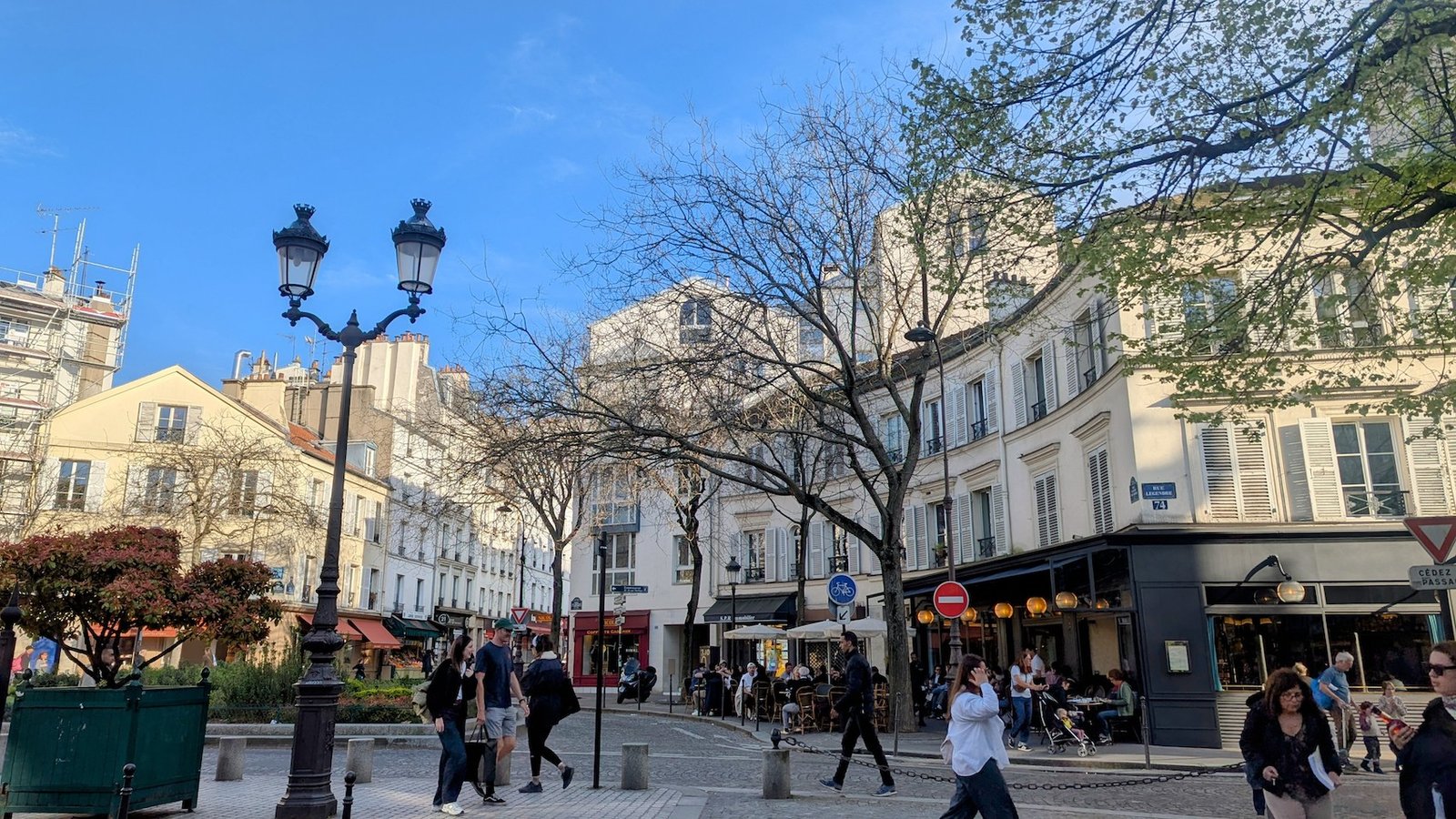 The animated Place du Docteur Félix Lobligeois in the 17th arrondissement on a warm Spring evening.